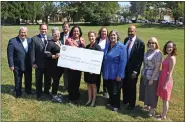  ?? SUBMITTED PHOTO/BECKY BRAIN ?? Chester County Commission­ers Michelle Kichline, Kathi Cozzone and Terence Farrell present a check to Kathryn Evans of Church Housing Corp, center left, along with other partners as part of Chester County’s investment in the new Melton Center Apartments affordable homes project in West Chester.