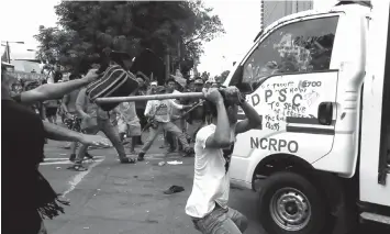  ?? ASSOCIATED PRESS FILE PHOTO ?? Protesters hit a PNP van after it rammed into protesters outside the US Embassy in Manila.