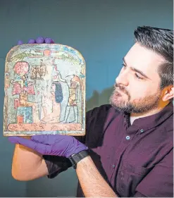  ?? Picture: Steve Macdougall. ?? Dr Dan Potter, assistant curator at the National Museum of Scotland, with a piece from the display – a wooden stela of an unknown woman.