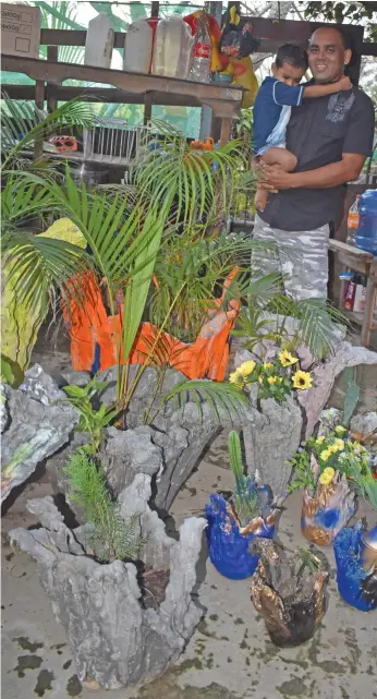  ?? Nadi. Photo: Mereleki Nai ?? Alinesh Ram and his son with the pot plants he made from recycled material at his nursery at Wailoaloa,