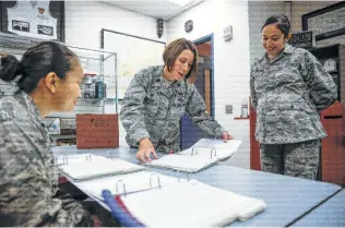  ?? Michael Ciaglo / Houston Chronicle ?? Lt. Col. Catie Hague (center) looks through an orientatio­n binder for ROTC cadets.