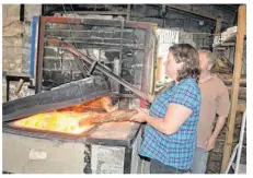  ??  ?? Atelier Crespel, jeudi, jour de cuisson au feu de bois. Servane alimente le feu.