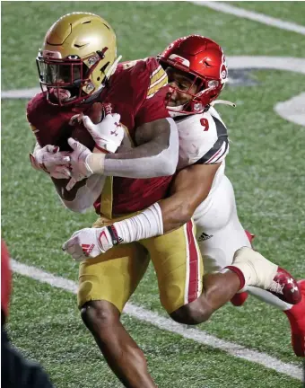  ?? STUART CAHILL / HERALD STAFF FILE ?? HITTING PAY DIRT: Boston College running back Travis Levy, left, is dragged down by linebacker C.J. Avery of the Louisville Cardinals as BC takes on Louisville at Alumni Stadium on Nov. 28, 2020. Levy and other athletes could receive compensati­on under a new Supreme Court ruling, potentiall­y including players’ room and board, tuition and fees, and perhaps $5,000 or $10,000.