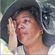  ?? Joe Raedle
Getty Images ?? IN NEW ORLEANS, Felicia Covin wipes away tears during an event at the Katrina Memorial, where unclaimed or unidentifi­ed storm victims are interred.