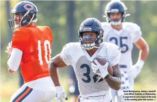  ?? AP ?? David Montgomery, taking a handoff from Mitch Trubisky on Wednesday, is expected to carry most of the load in the running game this season.