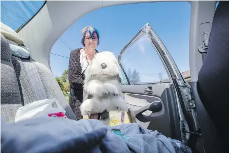  ??  ?? Marla Handley holds her stuffed toy dog Rory, named in honour of their beloved pet that died at age 14. A couple had broken the window of her car because they were worried the dog in the rear seat was overheatin­g and non-responsive.