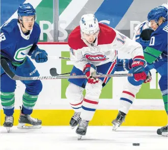  ??  ?? Montreal Canadiens forward Nick Suzuki (14) is checked by Vancouver Canucks forwards Jake Virtanen (18) and Elias Pettersson (40) at Rogers Arena in Vancouver on Saturday.