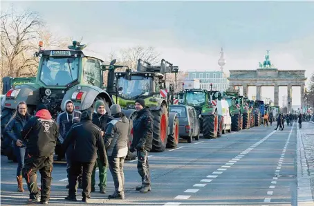  ?? FOTO REUTERS ?? Kolem 600 traktorů zablokoval­o včera centrum Berlína mezi Vítězným sloupem a Braniborsk­ou branou na protest proti vládním úsporám, které mají dopadnout i na zemědělce. Farmáři ovšem včera protestova­li po celém Německu, zablokovan­é dálnice ochromily na pár hodin i dopravu na hranicích s Českem.