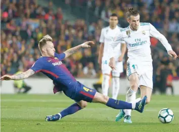  ?? — AFP ?? Barcelona’s Ivan Rakitic (left) vies with Real Madrid’s Gareth Bale during the Spanish league match at the Camp Nou Stadium in Barcelona on Sunday.