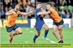  ??  ?? Australia’s Tom Banks (R) and Tom Wright (L) try to tackle France’s Melvyn Jaminet during the second of the three rugby union Test matches between Australia and France