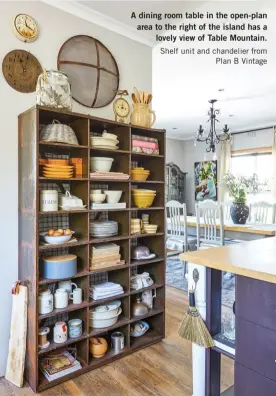  ??  ?? A dining room table in the open-plan area to the right of the island has a lovely view of Table Mountain. Shelf unit and chandelier from Plan B Vintage