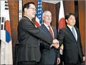  ?? YONG TECK LIM/AP ?? Defense Secretary Jim Mattis, center, joins South Korea’s Song Young-moo and Japan’s Itsunori Onodera on Sunday.