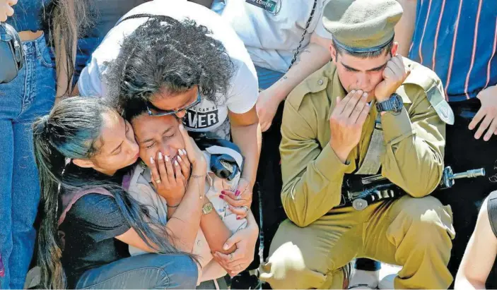  ??  ?? Un grupo de personas llora durante el funeral de un soldado israelí muerto en el conflicto bélico.