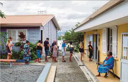  ?? AFP PIC ?? People queuing to vote at a polling station in Magenta district of Noumea, New Caledonia, during the first round of mayoral elections in France yesterday.