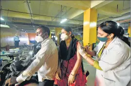  ??  ?? A medic administer­s a dose of Covid-19 vaccine at the drive-through site in Noida.