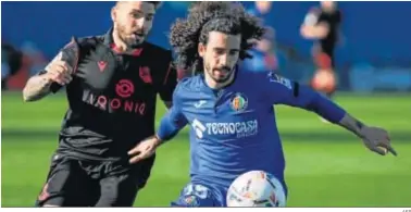  ?? AFP ?? Cucurella protege el balón ante Portu en el duelo celebrado en el Coliseum Alfonso Pérez.