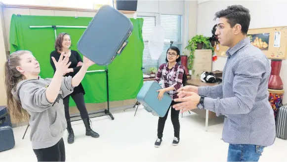  ?? MICHAEL BELL ?? Deaf Crows group members Sable Fink, left, Fatima Nafisa, and Mustafa Alabssi practise juggling suitcases, as artist-in-residence Chrystene Ells, centre left, looks on.