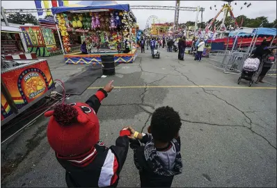  ?? Arkansas Democrat-Gazette/MITCHELL PE MASILUN ?? Friends Seth (left) and Gabe plan their ride strategy Saturday on the midway section of the Arkansas State Fair.