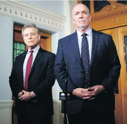  ??  ?? ‘I don’t believe it’s in anyone’s interests to have duelling premiers,’ says Premier John Horgan, seen at right with Environmen­t Minister George Heyman in Victoria on Wednesday. — THE CANADIAN PRESS