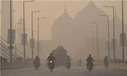  ?? Photograph: Arif Ali/AFP/Getty Images ?? Commuters ride along a road amid smoggy conditions in Lahore on 16 November, 2021. The city was temporaril­y declared the most polluted city in the world by an air quality monitor earlier on Wednesday.