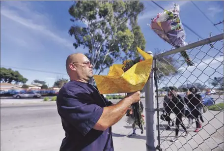  ?? Photograph­s by Francine Orr
Los Angeles Times ?? PAUL ROJAS of Los Angeles places flowers near where a teen was killed. Rojas said he has six sons. ““It breaks my heart,” he said.