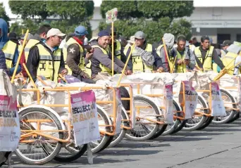  ??  ?? Los triciclos y carritos manuales, que sustituyen a 50% de los camiones recolector­es, llevarán la basura a las unidades que todavía tienen combustibl­e para que después sea trasladada al tiradero municipal Neza III.