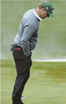  ?? AP PHOTOS ?? STIFF BREEZE: Charley Hoffman braces himself in the wind on the second hole during the first round of the Masters yesterday at Augusta National. Hoffman finished atop the leaderboar­d at 7-under.