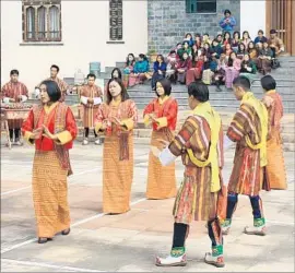  ?? Bhuwan Kafley For The Times ?? STUDENTS in traditiona­l dress perform at a literary festival in Thimphu, Bhutan’s capital. Western clothing is seen as decidedly casual in the kingdom.