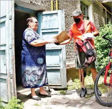  ?? AFP ?? Cyclist Talant Akynbekov (right) is one of 20 volunteers delivering needed insulin to Bishkek seniors.