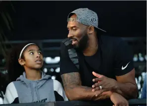  ?? Associated Press ?? ■ Former Los Angeles Laker Kobe Bryant and his daughter Gianna watch the U.S. national championsh­ips swimming meet July 26, 2018, in Irvine, Calif. Bryant, the 18-time NBA All-Star who won five championsh­ips and became one of the greatest basketball players of his generation during a 20-year career with the Los Angeles Lakers, died in a helicopter crash Sunday. Gianna also died in the crash.