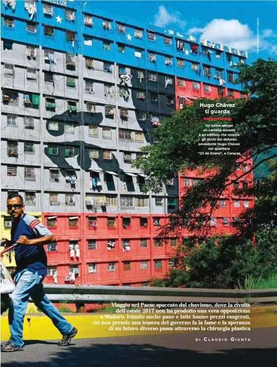  ??  ?? Un uomo spinge un carrello davanti a un edificio che mostra gli occhi del defunto presidente Hugo Chávez nel quartiere “23 de Enero”, a Caracas