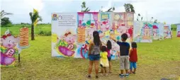  ??  ?? Kids reading the giant picture story book The Fourth Little Pig prepared by Eton City as one of the focal points in their activities