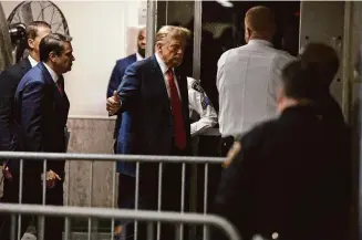  ?? Jefferson Siegel/Associated Press ?? Republican presidenti­al candidate and former President Donald Trump, center, at State Supreme Court in Manhattan after a break Monday, for the first day of his criminal hush money trial.