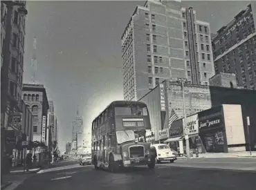  ?? ROBERT L. MILLER / MILWAUKEE JOURNAL ?? A Midland National Bank double-decker bus cruises down W. Wisconsin Ave. on July 15, 1974, the first day of the free shuttle’s service. This photo was published on the front page of the July 15, 1974, Milwaukee Journal.