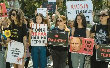  ?? LAURA BOUSHNAK/THE NEW YORK TIMES ?? Protesters in Kyiv call for action Saturday over POW deaths at a Russian detention site.