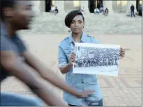  ??  ?? A Wits University student and activist holding a picture of the June 16, 1976, uprising that changed the history of this country. The student, who also took part in the #FeesMustFa­ll protest, believes the gates of education are not fully open.
