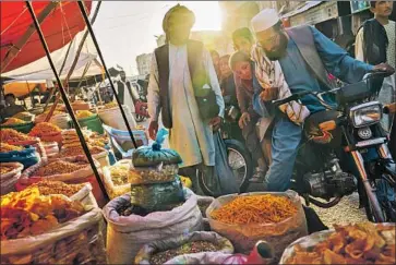  ?? RESIDENTS OF KANDAHAR Photograph­s by Marcus Yam Los Angeles Times ?? shop for spices and snacks on May 7 before iftar, the nightly meal during Ramadan. Taliban fighters have engaged in a months-long onslaught on the city, once their spiritual capital.