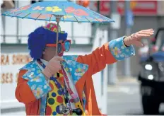  ??  ?? A clown waves at eventgoers during the annual Welland Rose Festival Grande Parade Sunday afternoon.