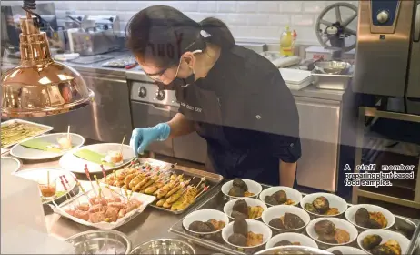  ??  ?? A staff member preparing plant-based food samples.