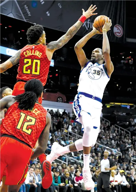  ?? ASSOCIATED PRESS ?? Golden State Warriors forward Kevin Durant (35) shoots as Atlanta Hawks forward John Collins (20) and forward Taurean Prince defend during the second half of an NBA basketball game in Atlanta.