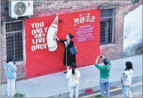  ?? PROVIDED TO CHINA DAILY ?? A visitor poses at one of the filming locations for the domestic comedy YOLO in Dongguan, Guangdong province, on Feb 12.