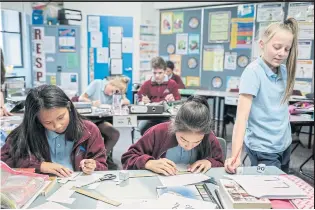  ??  ?? Students work on their English lessons at Pyramid Hill College. The small town of Pyramid Hill in Victoria state has become a model for integratio­n and revival.