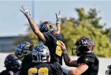  ??  ?? Team Black’s Dylan Cooper celebrates after a hauling in a deflected pass from Gage Lowry for a 35-yard touchdown.