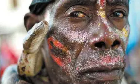  ?? HECTOR RETAMAL AGENCE FRANCE-PRESSE ?? Ce participan­t au carnaval d’Haïti déambule avec un serpent autour du cou.