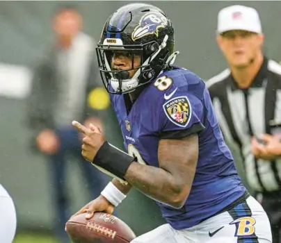  ?? JERRY JACKSON/BALTIMORE SUN ?? Ravens quarterbac­k Lamar Jackson looks for room to run during a game against the New York Jets on Sept. 11 in East Rutherford, New Jersey.