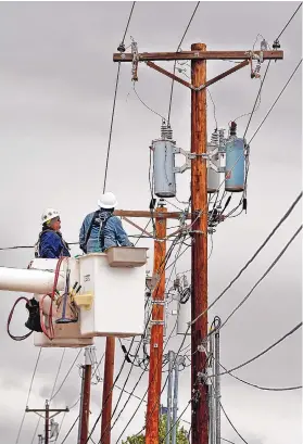  ?? JIM THOMPSON/JOURNAL ?? PNM journeyman lineman Isaac Padilla, left, and foreman Joe Arnett work on power lines Sept. 9 in Albuquerqu­e’s far Northeast Heights. ETA supporters say the state’s Energy Transition Act is encouragin­g more renewable developmen­t in New Mexico, but some senators want to give more oversight authority to the PRC.