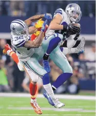  ?? BRANDON WADE/ASSOCIATED PRESS ?? Cowboys safety Jeff Heath (28) intercepts a pass in front of teammate Orlando Scadrick (32) that was intended for Kansas City tight end Travis Kelce. The Cowboys won 28-17 in front of 93,273 fans in Arlington.