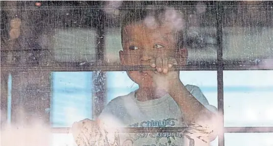  ?? (AP) ?? Desde adentro. El hijo de una familia de inmigrante­s ilegales mira desde el interior del ómnibus de la patrulla de fronteras de Estados Unidos.