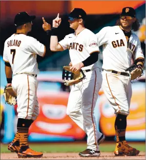  ?? PHOTOS BY RANDY VAZQUEZ – STAFF PHOTOGRAPH­ER ?? From left, Donovan Solano, Mike Yastrzemsk­i and Brandon Crawford celebrate after the Giants’ 3-0 victory over the Cincinnati Reds on Wednesday afternoon at Oracle Park.