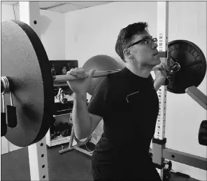  ??  ?? Caulfield demonstrat­es a weights workout while in his home gym
— his family’s “favourite room in the house.”